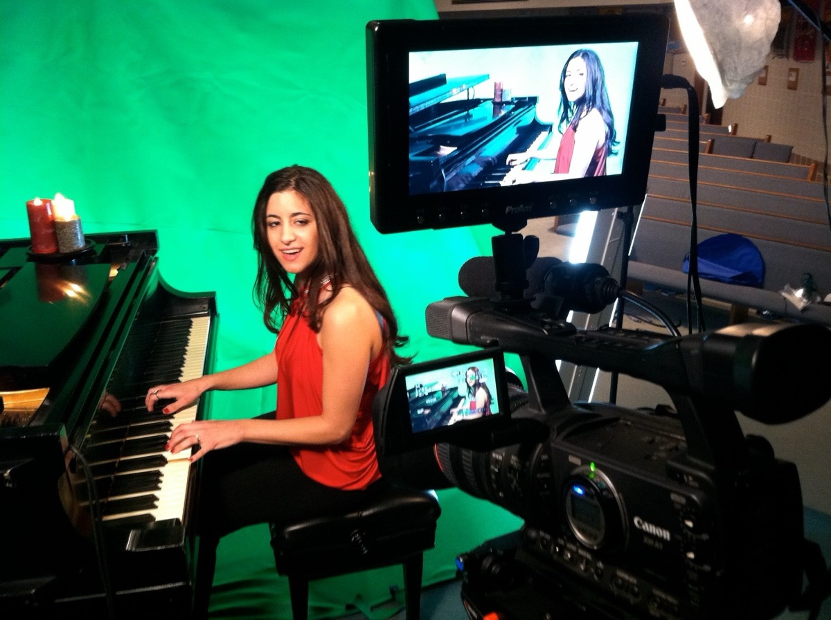 Pianist filmed on a green screen set with a camera monitor